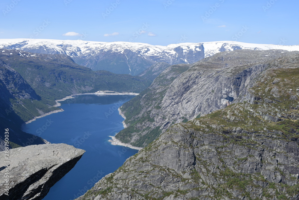 The world-famous stone ledge on Mount Skigedal, in Norway, rises above Lake Ringedalsvatn The world-famous stone ledge on Mount Skigedal, in Norway, rises above Lake Ringedalsvatn