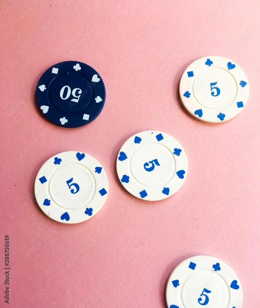 Blue and white casino chips on pink background. Poker play. Blue and white casino chips on pink background. Poker play.