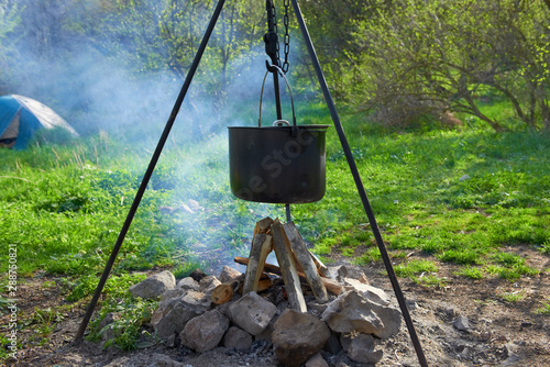 Pot boiling on fire in fireplace in forest