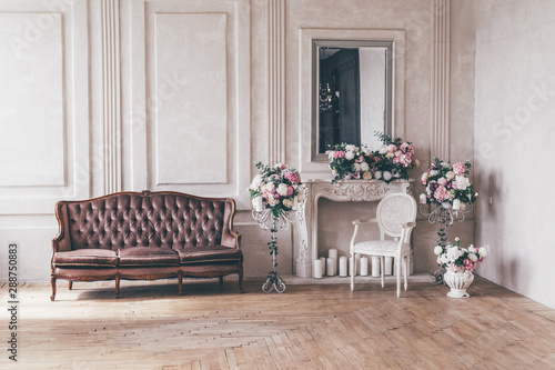 Fotografie Vintage interior sofa with a vase of flowers in shabby chic style