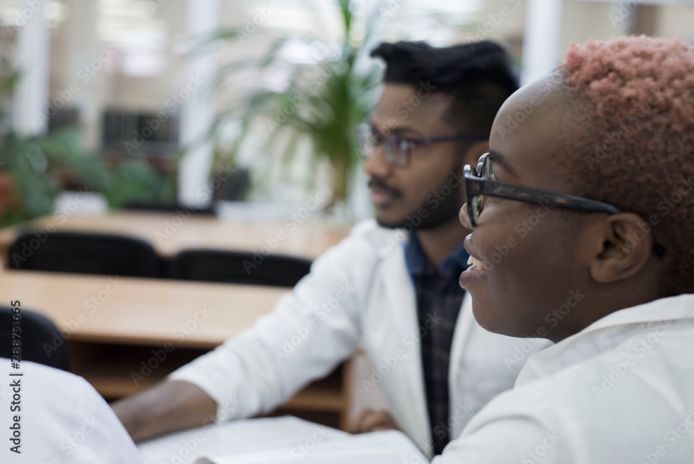 couple of young mixed race doctors sitting at a table at a medical conference couple of young mixed race doctors sitting at a table at a medical conference