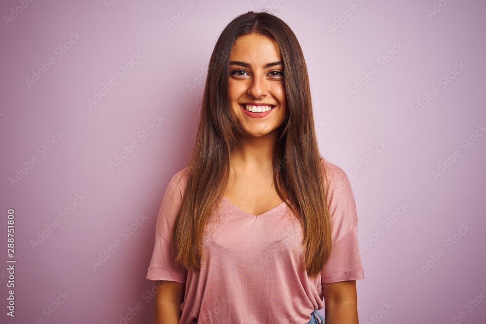 Young beautiful woman wearing t-shirt standing over isolated pink background with a happy and cool smile on face. Lucky person. Young beautiful woman wearing t-shirt standing over isolated pink background with a happy and cool smile on face. Lucky person.