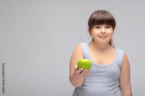 Foto overweight girl with a green Apple . proper diet