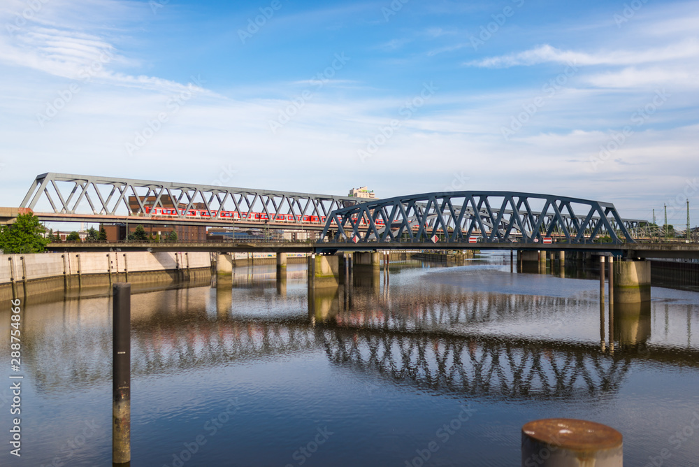 Railroad bridges across the Billhafen at the north-east end of the inland port in Hamburg. The water canal is an anabranch of the Elbe river