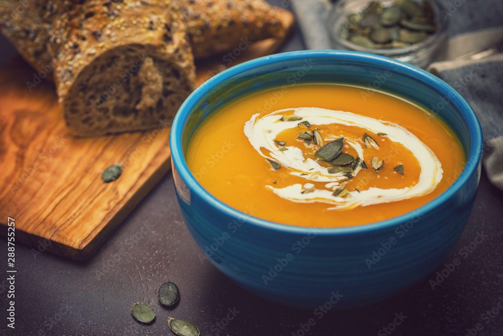 Homemade pumpkin soup served with cream and pumpkin seeds Homemade pumpkin soup served with cream and pumpkin seeds