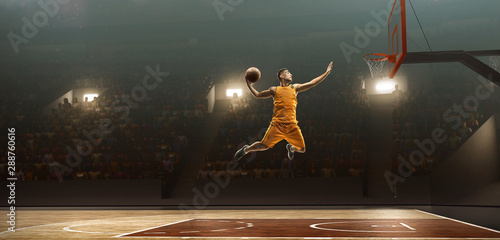 Foto Professional basketball player on sports arena in action with the ball