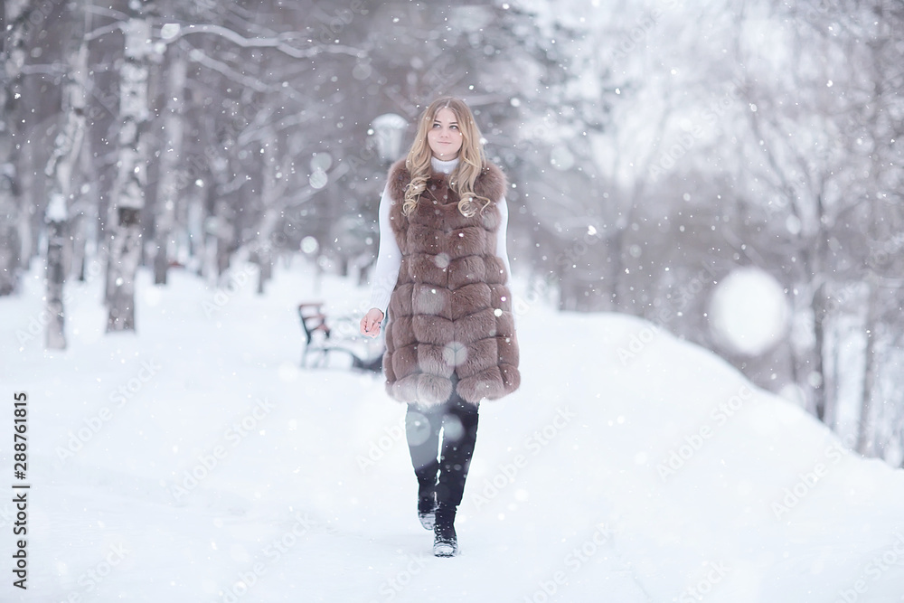 walk in a winter park christmas girl / beautiful model posing in the winter season walk city park