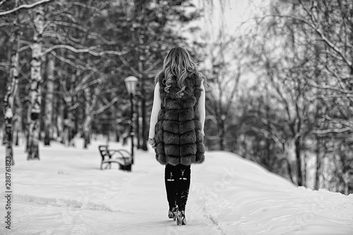 walk in a winter park christmas girl / beautiful model posing in the winter season walk city park