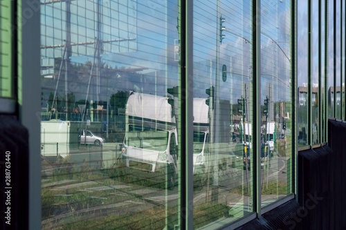 Acoustic road screen  sound absorbing panel   next to the expressway. Moving cars visible through the glass.