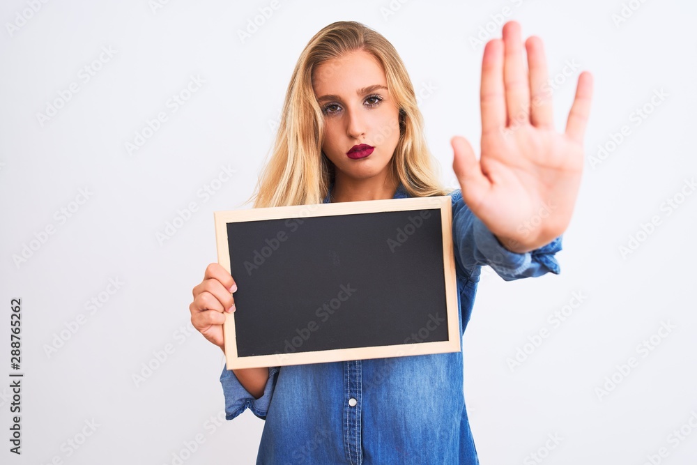 Young beautiful teacher woman holding blackboard standing over isolated white background with open hand doing stop sign with serious and confident expression, defense gesture Young beautiful teacher woman holding blackboard standing over isolated white background with open hand doing stop sign with serious and confident expression, defense gesture