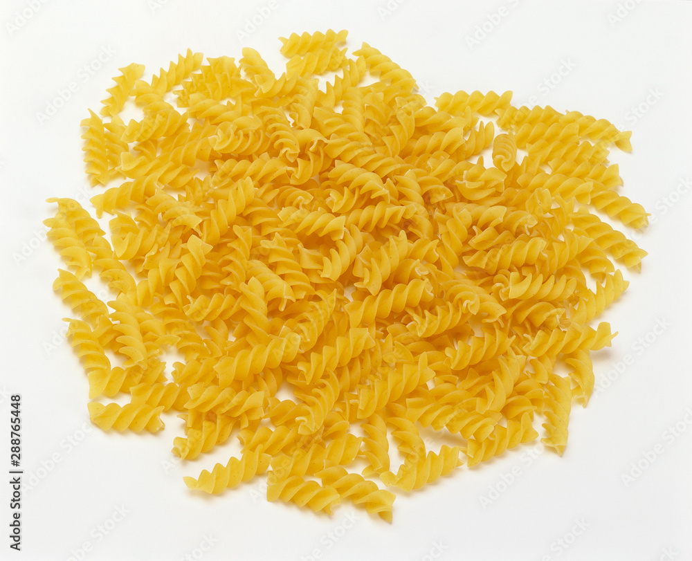 uncooked Fusilli Pasta Pile against white uncooked Fusilli Pasta Pile against white