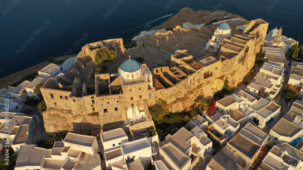 Aerial drone photo of iconic medieval fortified castle overlooking the deep blue Aegean sea in Chora of Astypalaia at sunset, Dodecanese islands, Greece