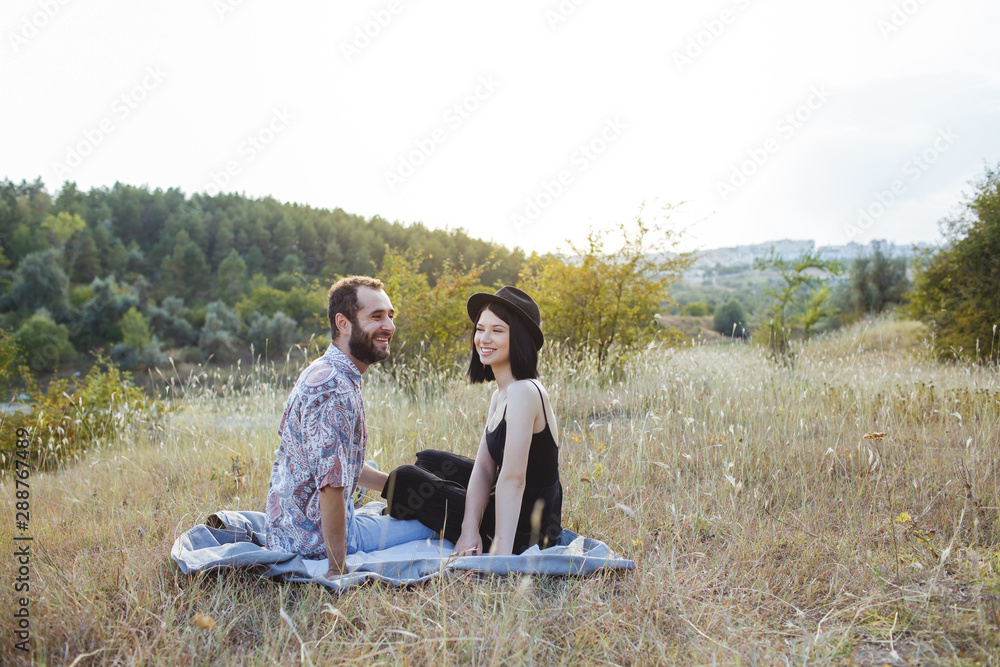 Couple feel happy on a field at sunset.