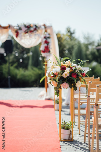Decoration wedding arch with white and pink flowers on a green natural background.
