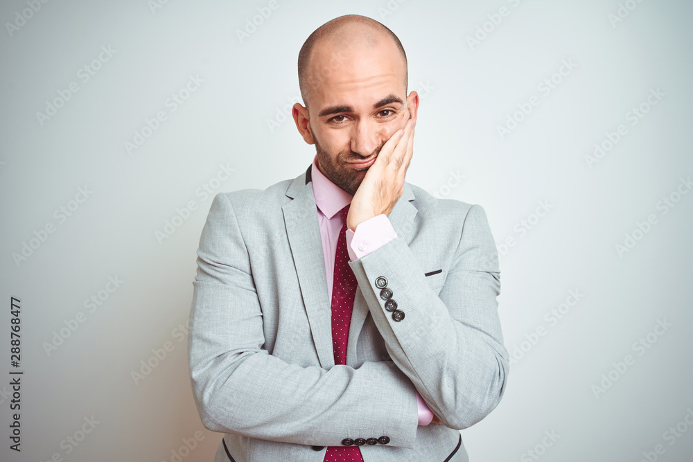 Young business man wearing suit and purple tie over isolated background thinking looking tired and bored with depression problems with crossed arms. Young business man wearing suit and purple tie over isolated background thinking looking tired and bored with depression problems with crossed arms.