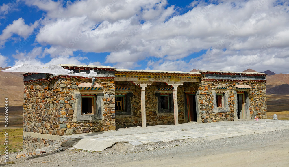 CLOSE UP: Beautiful Tibetan stone house is left empty at the side of a road.