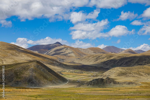 Spectacular view of meadows covering the valley leading up to a Tibetan village.