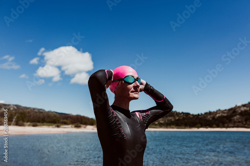 Fotografie woman in her 40s wearing a neoprene and waiting to swim in the lake
