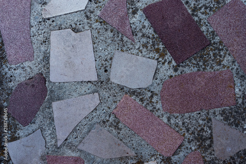 Background in the form of pieces of an old multi-colored floor tile in hardened concrete  top view