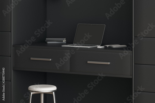 Modern style workspace with black furniture and laptop with blank screen on the table.