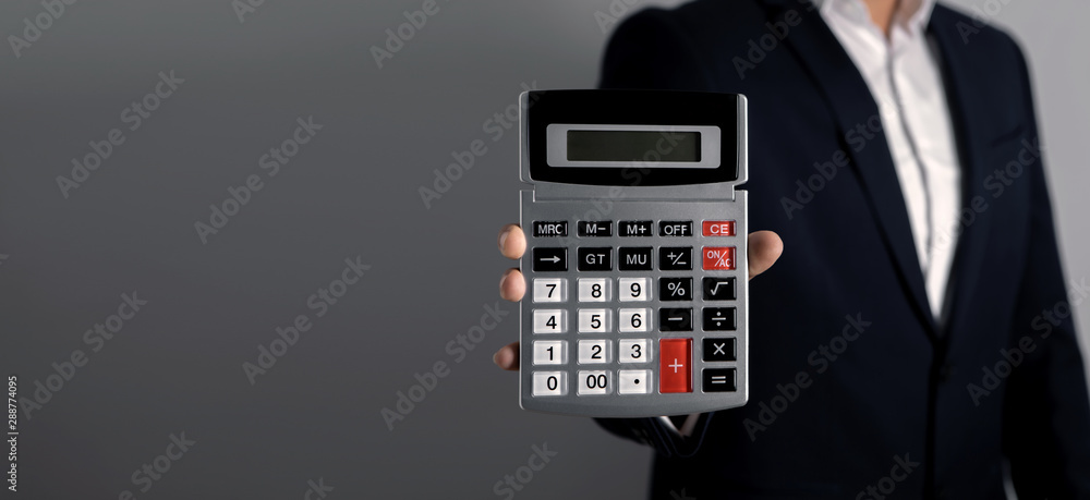 businessman holds a calculator in his right hand businessman holds a calculator in his right hand