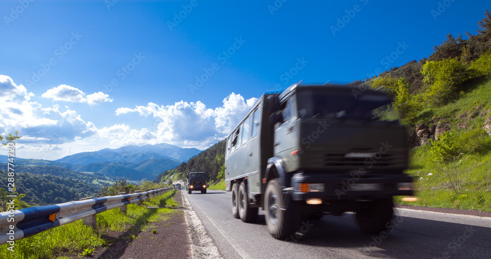 convoy of military trucks driving along the highway
