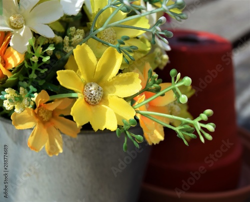 Close up of fake flowers in front of red pot