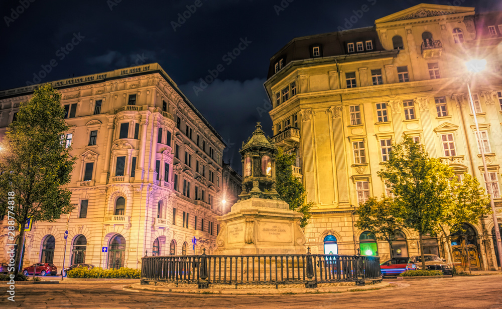 Budapest / Hungary - August 30 2019: Ancient beautiful gothic building and street car traffic on the night streets of Budapest, Hungary. Tourist historical quarter of the capital of Hungary