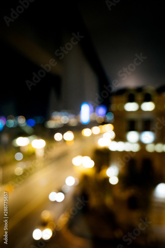 Defocused blurred lights of Baku city at night - main avenue with multiple cars driving fast - tilt-shift lens used