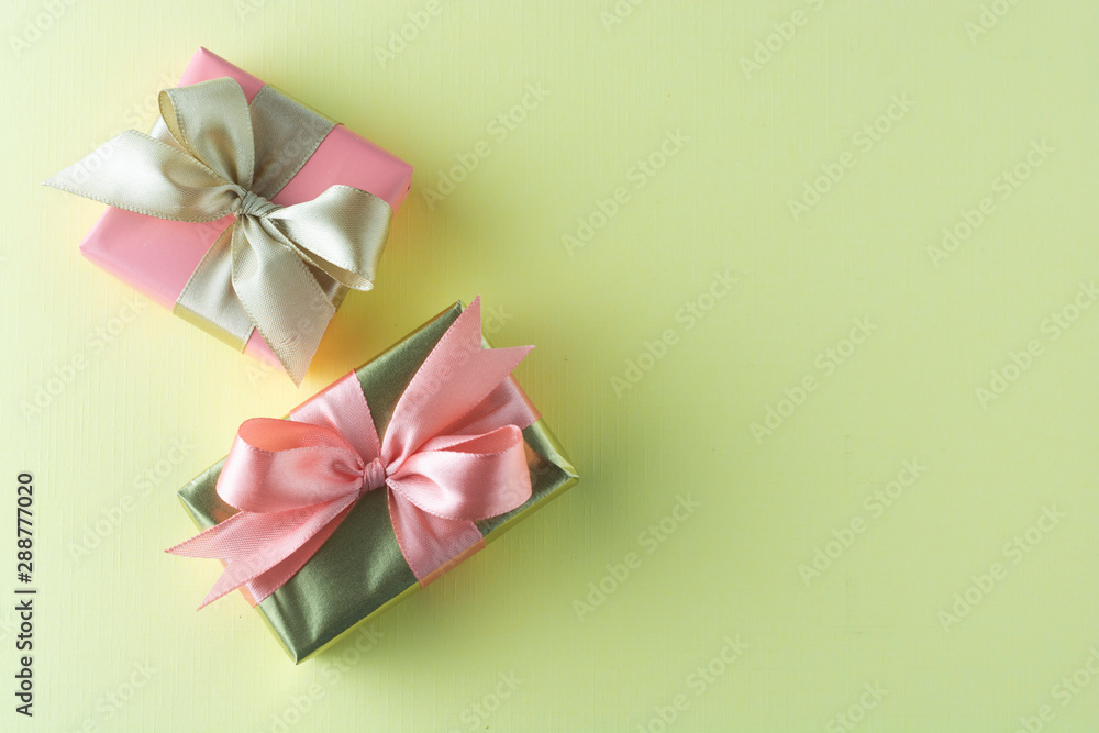 Goldenand pink gift isolated on yellow background. Birthday, Christmas party mock up. Copy space. Goldenand pink gift isolated on yellow background. Birthday, Christmas party mock up. Copy space.