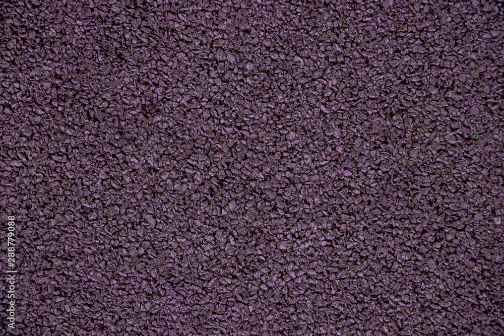 Mauve background from rubber coating of a sports ground. Recycled rubber tires are cut into small pieces, glued and painted in purple Mauve background from rubber coating of a sports ground. Recycled rubber tires are cut into small pieces, glued and painted in purple