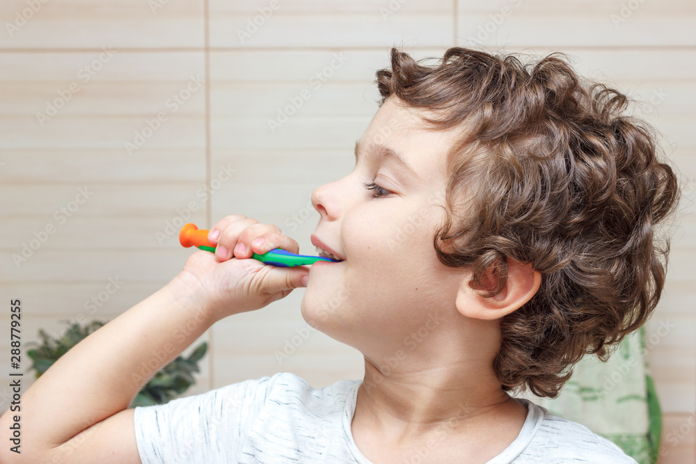 Happy little boy brushing his teeth in bathroom in front of mirror, oral hygiene Happy little boy brushing his teeth in bathroom in front of mirror, oral hygiene