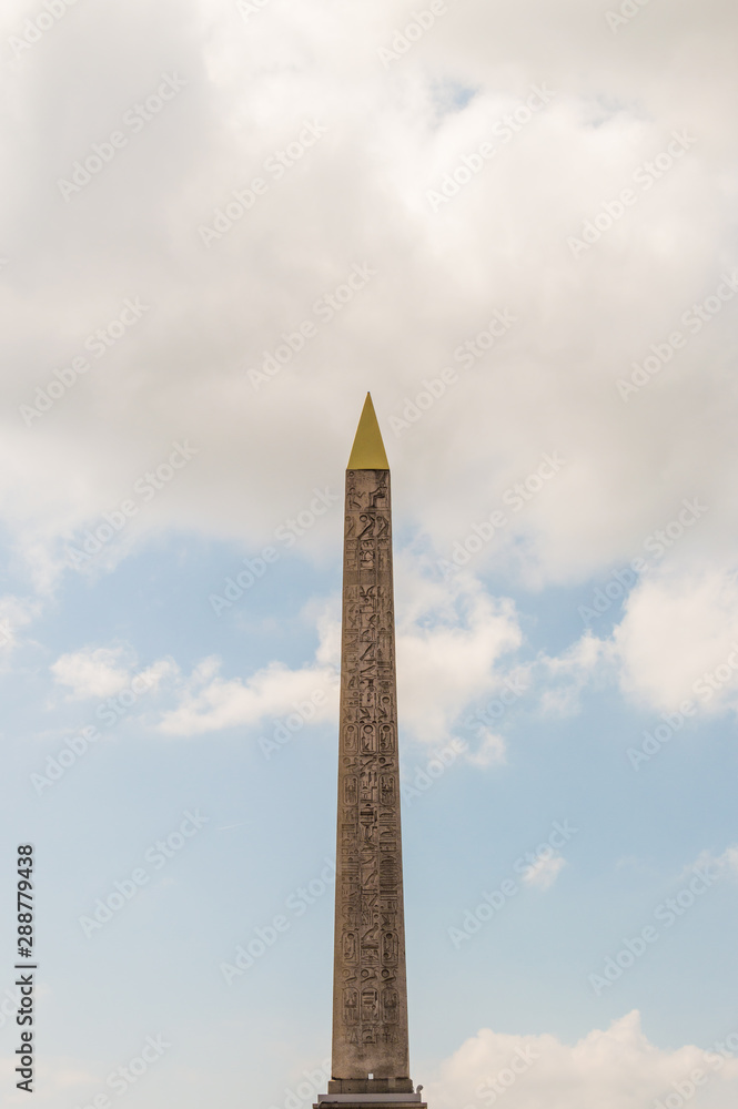 Vertical view of Egyptian Luxor obelisk located at Place de la Concorde, Paris, France on a cloudy day.  Detailed hieroglyphs can be seen