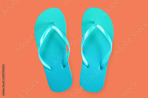 Green flip flops isolated on red background. Top view. Flat lay