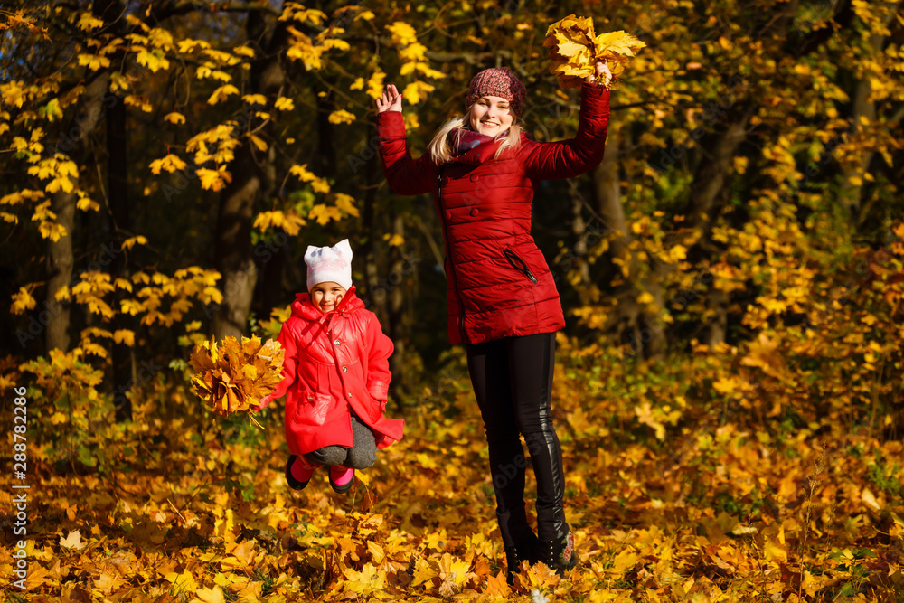 Young mother playing with her daughter in autumn park Young mother playing with her daughter in autumn park