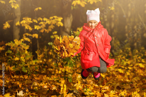 Young daughter playing in autumn park
