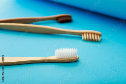 Dental care with eco friendly bamboo toothbrush on blue background. Zero waste and plastic free concept.