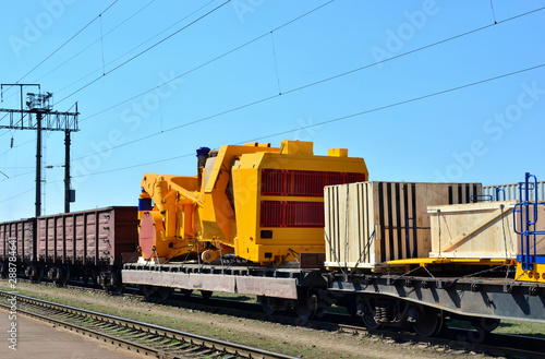 Logistics transportation heavy mining dump truck by rail. Yellow mining truck disassembled into parts, cab, body, electric motor, drive, wheels, loaded onto a cargo railway platform. - Image