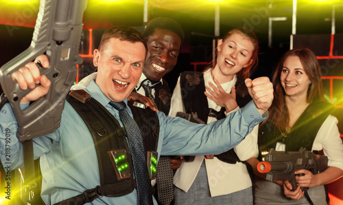 males and females in business suits posing at laser tag room