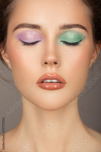 Fashion portrait of young woman. Colorful eye shadows. Perfect skin.