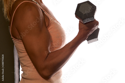 Side view of anonymous female weightlifter arm holding metal weight flexing bicep over white, not isolated.