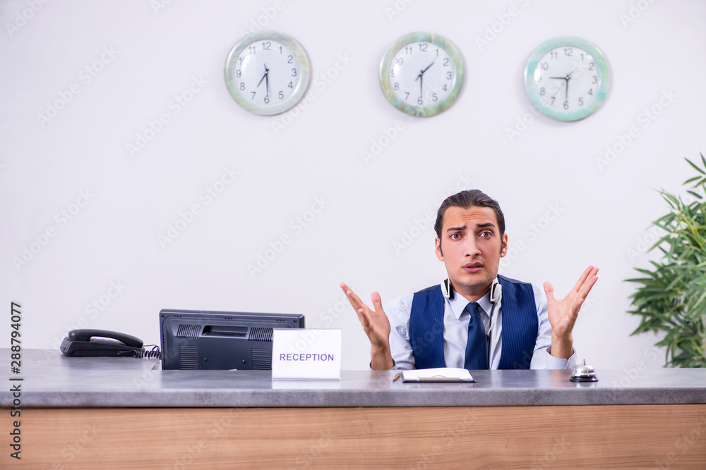 Young man receptionist at the hotel counter Young man receptionist at the hotel counter