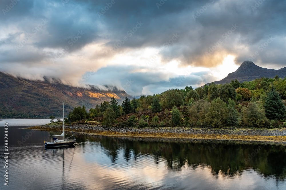 Colorful sunrise clouds on a lake in Scotland