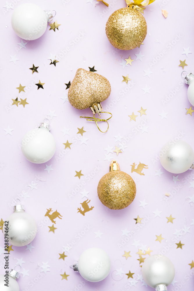 Fototapeta premium christmas balls arranged on a violet background, christmas concept and idea, golden , silver and white balls with confetti, flatly composition, christmas glitter holiday, Xmas patter and background.