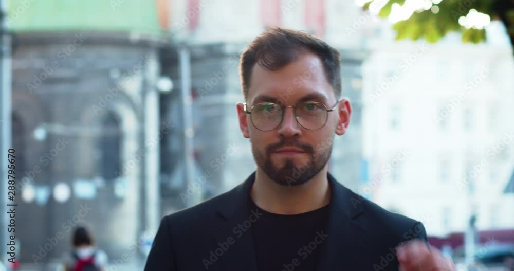 Handsome portrait of young successful man in business suit putting off glasses smiling outdoor at beautiful city background. Handsome portrait of young successful man in business suit putting off glasses smiling outdoor at beautiful city background.