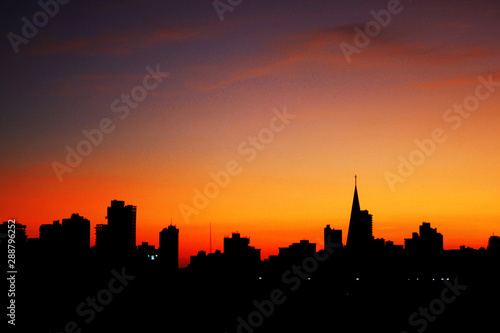 Sunrise with city silhouette showing the buildings and the catheral in Maringa, Parana, Brazil