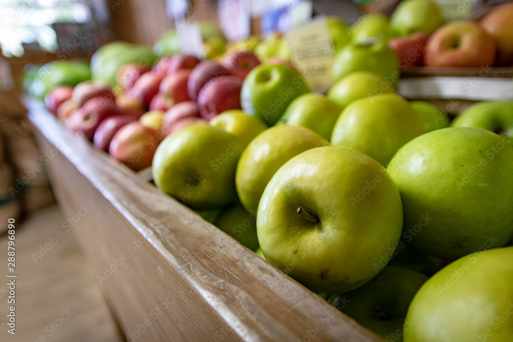 A variety of apples on display for sale at a farmer's market or fruit stand. A variety of apples on display for sale at a farmer's market or fruit stand.