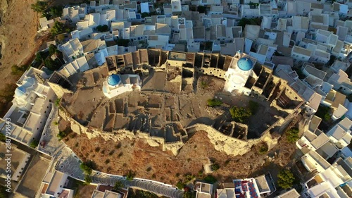 Aerial drone video of iconic medieval fortified castle overlooking the deep blue Aegean sea in Chora of Astypalaia island, Dodecanese islands, Greece photo