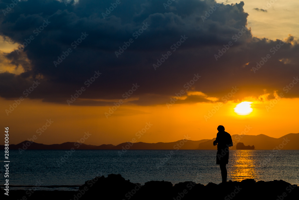 Fototapeta premium Siluate lonely man at the beach before sunset