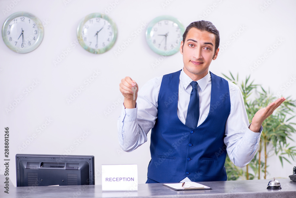 Young man receptionist at the hotel counter Young man receptionist at the hotel counter